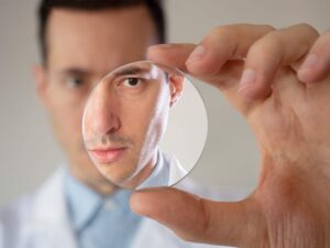 Person holding a cool compress over closed eyes in a bright, tidy home.